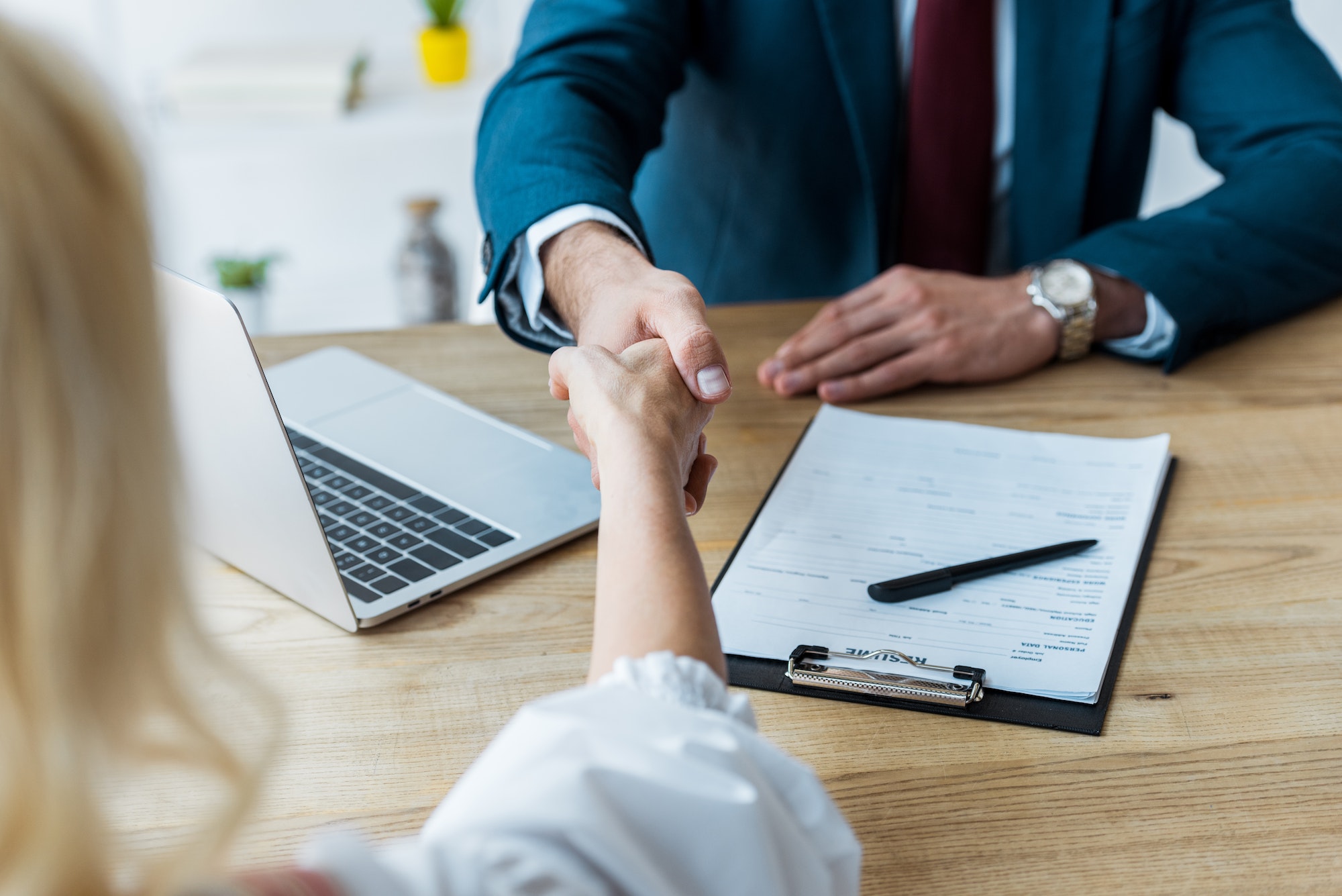 selective focus of employee and recruiter shaking hands